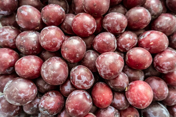 photo of a lot of plums on the counter of the store