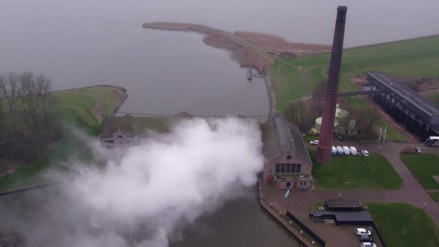 Drone filming The Woudagemaal under steam, aerial backwards 4k