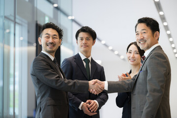 契約を勝ち取ったビジネスマン　営業マンと社長と社員のビジネスシーン