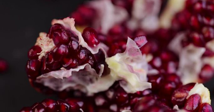 Break a ripe pomegranate with red grains into pieces with your hands, divide a ripe red pomegranate into pieces