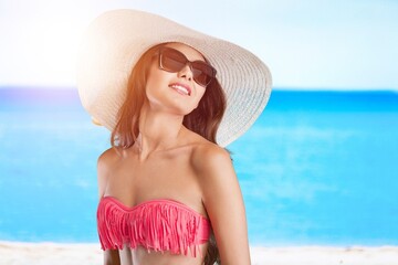Happy beautiful woman at the beach enjoying sun