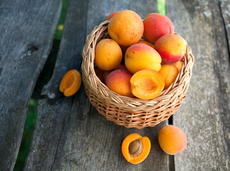 Fototapeta na wymiar apricots in a basket on wooden background
