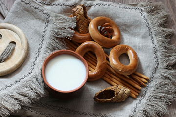 food milk in a glass straw bagels and pretzels on flax background