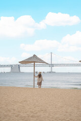 Woman traveller is sightseeing and looking at Gwangalli Beach in Busan, South Korea. 