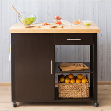 A Contemporary Kitchen Island Featuring An Array Of Fresh, Colorful Produce Stored In Woven Baskets