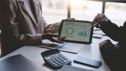 Business people meeting explaining the financial graph data and marketing plan on tablet. Group of business people at meeting assessment the state of business investment and marketing.