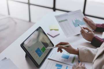 Business people meeting explaining the financial graph data and marketing plan on tablet. Group of business people at meeting assessment the state of business investment and marketing.