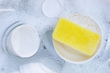 Dishes and bowls in water and bubbles of dishwashing liquid