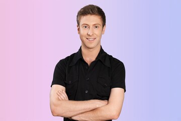 Obraz premium Confident young happy man with crossed arms