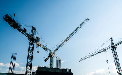 Construction site banner background. Construction industry and business concept. Cranes on a blue background.