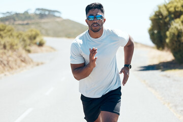 Man, fitness and running in nature for workout, cardio exercise or training outdoors. Fit, active and sporty male person, athlete or runner exercising on mountain asphalt, road or street outside