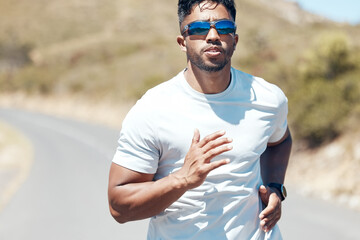 Fototapeta premium Man, fitness and running in nature for exercise, cardio workout or training outdoors. Fit, active and sporty male person, athlete or runner exercising on mountain asphalt, road or street outside