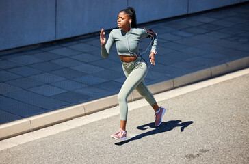 Running, workout and fast black woman training for a marathon, health and wellness in a city or town street. Healthy, exercise and young person, runner or athlete run with speed for fitness or energy