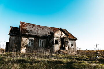 Abandoned 19th century house in a rural field at summer.Creepy summer evening.