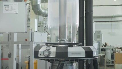 Industrial machinery deals with the plastic film processing on the production line. Blown extruder equipment processing the plastic film. Plastic film processing at the manufacturing facility.