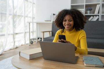 Young African American woman using mobile phone to attend online training Talk while learning via...