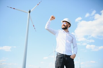 Engineer in field checking on turbine production