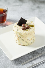 Single person mini cake with pistachio and white chocolate on a white porcelain plate