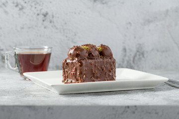 Cake with profiteroles with tea on stone table