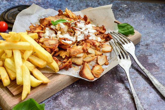  Portion of Spicy  kebab  Chicken  duner  gyros with french fries and garlic sauce  on  wooden board