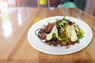 Tasty traditional food dish in plate on the desk