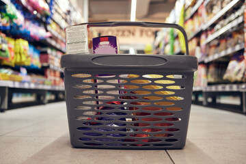 Closeup of basket with groceries, floor with shopping and supermarket, food product with retail and...