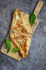  Traditional Turkish cuisine. Baked Pide dish with chicken ,  cheese and  herbs on  wooden background.  Turkish pizza pide