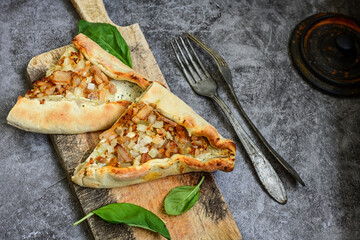  Traditional Turkish cuisine. Baked Pide dish with chicken ,  cheese and  herbs on  wooden background.  Turkish pizza pide