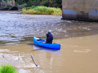 Fototapeta na wymiar Blue Canoe Under Bridge