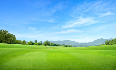 Golf course with mountain and blue sky background.