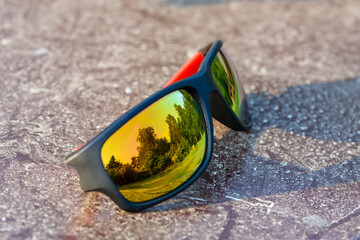 Okulary przeciwsłoneczne polaryzacyjne z filtrem uv w których odbija się zielony park