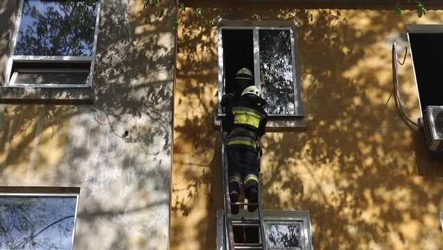 View of a brave firefighter in a protective uniform. Rescuer in protective gear. Firefighters put out a fire in a residential building. DNIPRO, UKRAINE  April 30, 2021