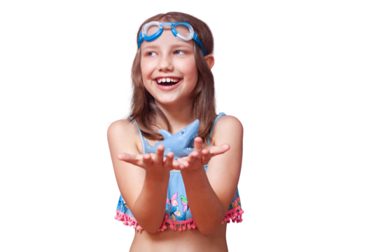 a girl in goggles for swimming and a blue swimsuit holds a toy shark and rejoices laughs near the pool of the river sea water on a white background isolate - Powered by Adobe