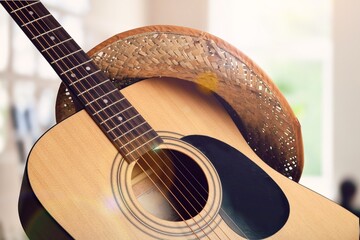 Acoustic guitar, against a light room background