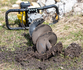 Worker digs the ground with a gasoline blower in the garden