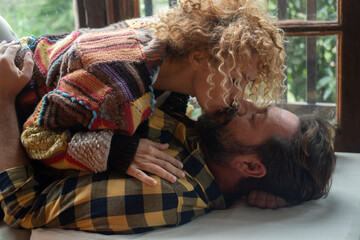 Adult couple kissing at home with passion laying on the floor. Woman above man below. Desire and...