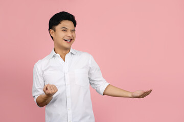 Successful young asian businessman and fist pump isolated on pink background with copy space.