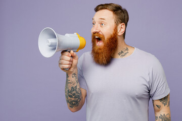 Young redhead bearded man wear violet t-shirt casual clothes hold in hand megaphone scream...