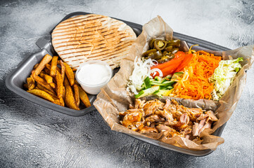 Doner kebab Shawarma on a plate with french fries and salad in box to go, take away. White...