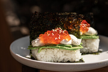 Portion of japanese hand rolls with caviar and avocado