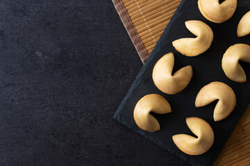 Traditional fortune cookies black slate background. Top view. Copy space