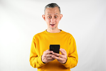 Portrait of Adult Asian man showing happy expression and smiling with holding his mobile phone. 
