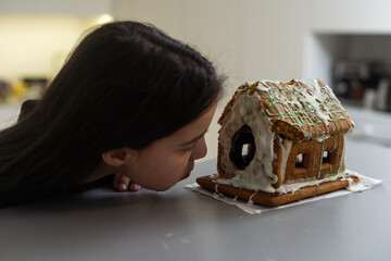 Kids with gingerbread house, A teenage girl is eating a gingerbread house