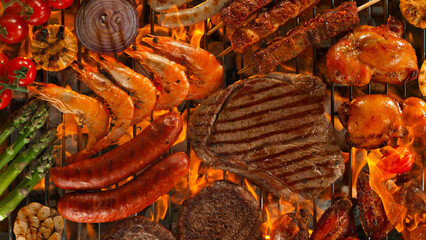 Top shot of various types of meat on garden grill with roaring flames