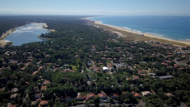 Aerial drone cinematic Hoosegor Capbreton France Bay of Biscay Quiksilver Pro waves central beach over city town street cars roadway world surf league sunny mid day slowly pan up forward movement