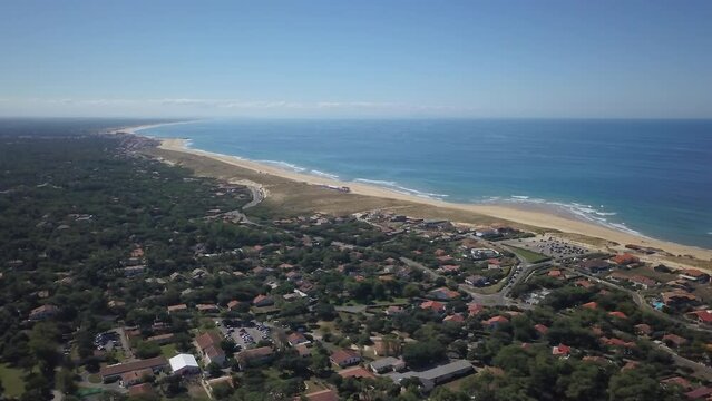 Aerial drone cinematic Hoosegor Capbreton France Bay of Biscay Quiksilver Pro waves central beach over city town street cars roadway world surf league sunny mid day slowly circling right movement