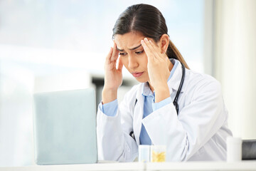 Mental health, woman doctor with headache and laptop at her desk in a modern office. Anxiety or...