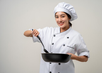 Young beautiful asian woman chef in uniform holding turner and iron Frying pan utensils cooking in the kitchen various gesture on isolated background. woman occupation chef restaurant and hotel. - obrazy, fototapety, plakaty