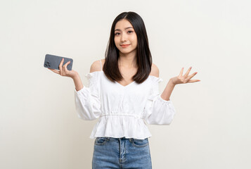 Naklejka premium Pretty young asian woman using smartphone standing on isolated white background. Excited Beautiful young asian shopping online payment with mobile phone. Playing game on smartphone