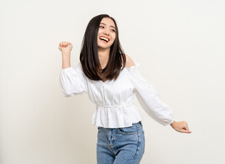 Cheerful cute asian female teenager listen to the music and dancing on isolated white background....